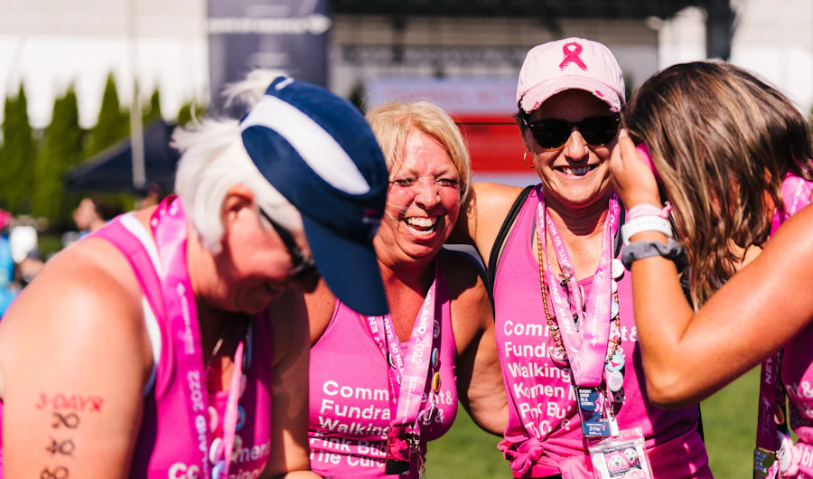 Smiling women in pink shirts at a breast cancer fundraising walk